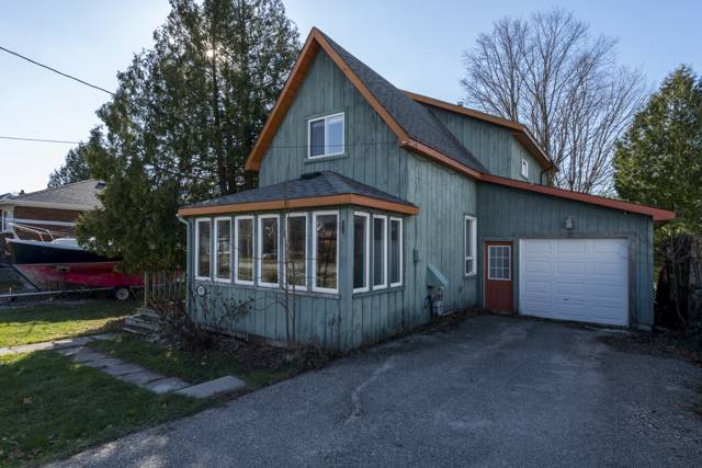 Front of house: Board-and-batten siding, attached garage and paved drive